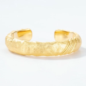 Artistic golden cuff bracelet with brushed lava texture and minimal open design