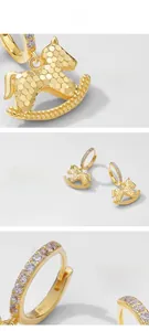 Detailed macro view of S925 silver rocking horse earrings with gold plating and zircons