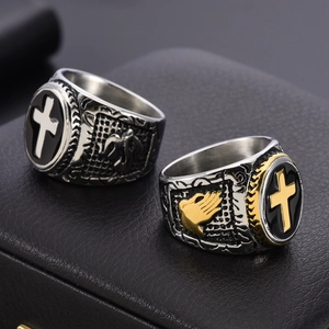 Detail of vintage gothic rings with black enamel, metallic crosses, and prayer hand reliefs