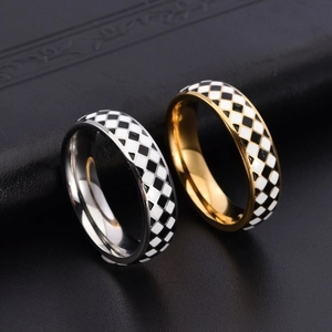 Detail showing gold and silver checkered enamel rings on a black leather background