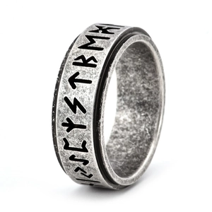 Close-up of vintage Nordic runes engraved on a rotating stainless steel spinner ring