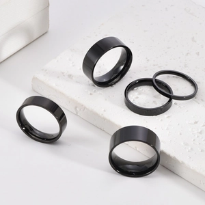 Sleek black stainless steel unisex ring set in 2-10mm widths on marble stone