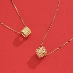 S925 sterling silver gold-plated necklaces with matte cylinder pendants on red background