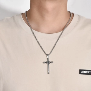 Detail of male model wearing silver stainless steel cross pendant with box chain