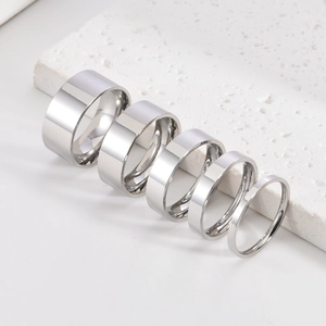 Set of five minimalist silver polished rings with varied widths on white stone