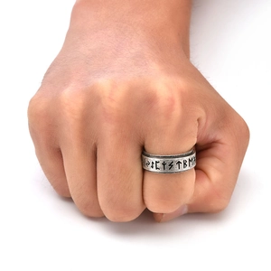 Macro detail of Nordic Viking spinner ring with engraved Elder Futhark runes on band