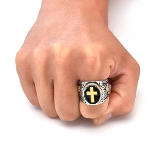 Close-up of vintage titanium steel cross ring with black enamel and embossed religious detail