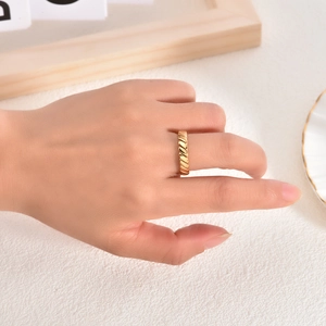 Close-up of a gold woven rope texture ring worn on finger with minimalist aesthetic