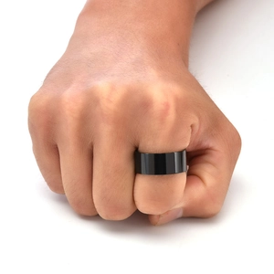 Close-up of a minimalist black polished stainless steel wide ring worn on a man's hand