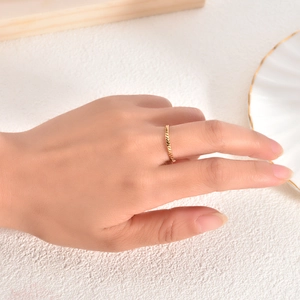 Detailed view of an 18K gold braided rope ring worn on a finger, minimalist style
