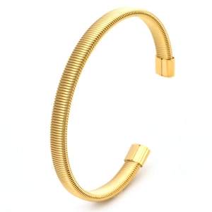 Detail of the golden C-shaped spring bracelet with polished cylindrical ends and textured surface