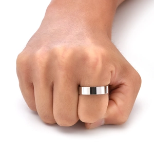 Close-up of a minimalist silver stainless steel band ring worn as a men's pinky ring