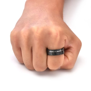 Detail of 8mm faceted black tungsten ring with silver inlay on male hand