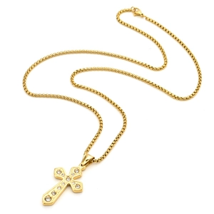 Gros plan du pendentif croix dorée serti de zircons clairs et chaîne à mailles boîte