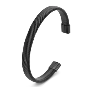 Close-up of matte black spiral coil spring bracelet with polished metal end caps