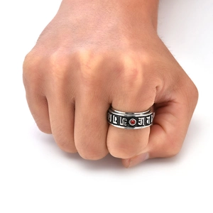 Macro shot of silver titanium ring with red gemstone and six-character mantra details