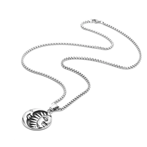 Detail of silver titanium steel punk pendant featuring embossed sun and moon faces