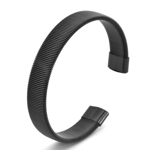 Detail of black flexible C-shaped bracelet with industrial spring texture and square ends