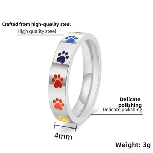 Détail d'une bague en titane doré de 4 mm avec empreintes de pattes arc-en-ciel et mesures