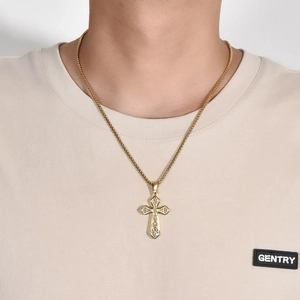 Détail macro du pendentif croix dorée avec pierres de zircone cubique serties en pavé