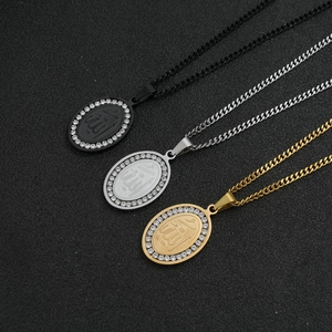 Macro view of oval Allah pendant necklaces in black, silver, and gold with crystal pavé