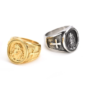 Detailed view of vintage religious signet rings featuring embossed icons and cross details