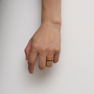 Gros plan d'une bague arc-en-ciel en acier inoxydable portée à la main style LGBTQ
