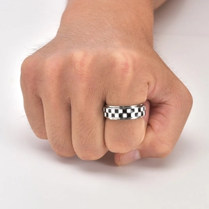 Close-up of black and white checkered enamel spinner ring made of durable titanium steel