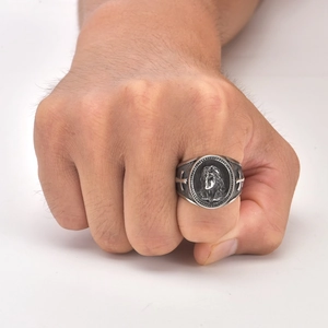 Macro shot of silver retro seal ring featuring a portrait relief and side cross details