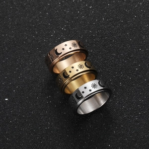 Rotating stainless steel fidget rings with celestial sun, moon, and star engravings