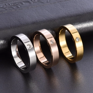 Three minimalist 18K gold-plated stainless steel rings with a single diamond in silver and gold