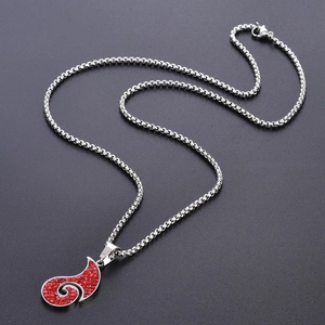 Détail du pendentif tourbillon en strass rouges avec chaîne box argentée sur fond texturé