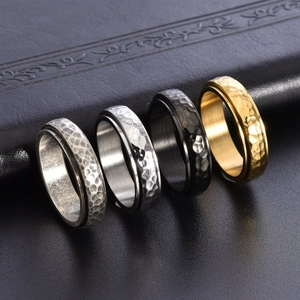 Set of four vintage spinner rings with hammered texture in gold, black, and silver steel