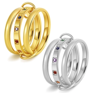 Detail of interlocking three-band rings in gold and silver with colorful zircon accents