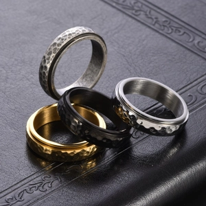 Set of four hammered stainless steel spinner rings in silver, black, and gold finishes
