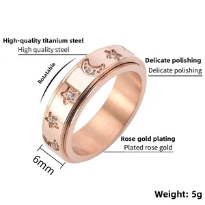 Detail of rose gold spinner ring with star moon engravings and small inset diamonds