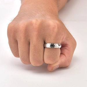 Close-up of vintage silver titanium ring with hammered texture on a male hand