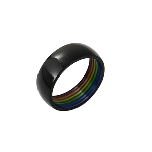 Gros plan sur une bague noire en acier titane avec bande intérieure rayée arc-en-ciel