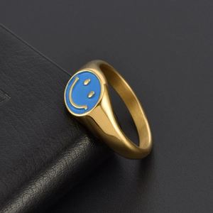 Detail of 18K gold-plated signet ring with blue enamel smiley face on black leather