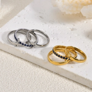 Macro shot of 18K gold and silver triple interlocking rings with navy blue sapphire pave