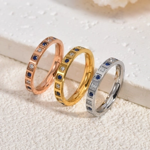 Detailed view of stacked stainless steel rings with blue and white square zircon settings