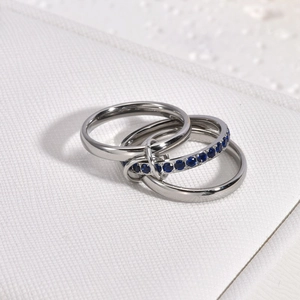 Macro view of interlocking triple band rings featuring blue stone pavé in 18K gold plating