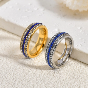 Luxury three-row crystal rings in gold and silver with blue stones on stone background