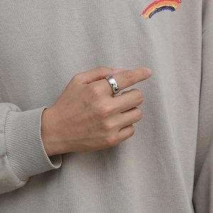 Détail d'une bague en acier titane argenté avec texture carte du monde et fini poli