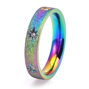 Detail of rainbow gradient titanium ring with frosted star texture and small diamonds