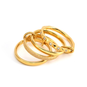 Close-up of a 5-piece 18K gold-plated ring set with frosted and diamond-studded textures