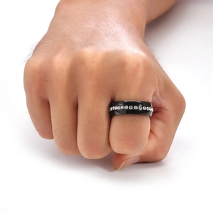 Macro detail of men's black stainless steel ring featuring a row of channel-set white diamonds