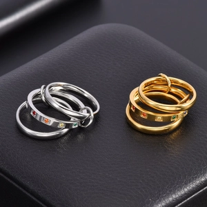 Macro detail of interlocked 18K gold and silver rings with vibrant colorful gemstones