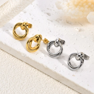 Boucles d'oreilles minimalistes à double anneau entrelacé or et argent sur présentoir