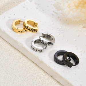 Detailed view of three pairs of Viking rune earrings in gold, silver, and black finishes